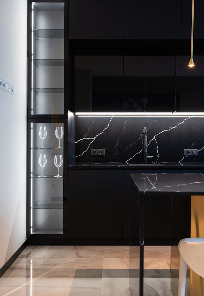 Interior of contemporary kitchen with marble backsplash and black cabinets in contemporary spacious apartment