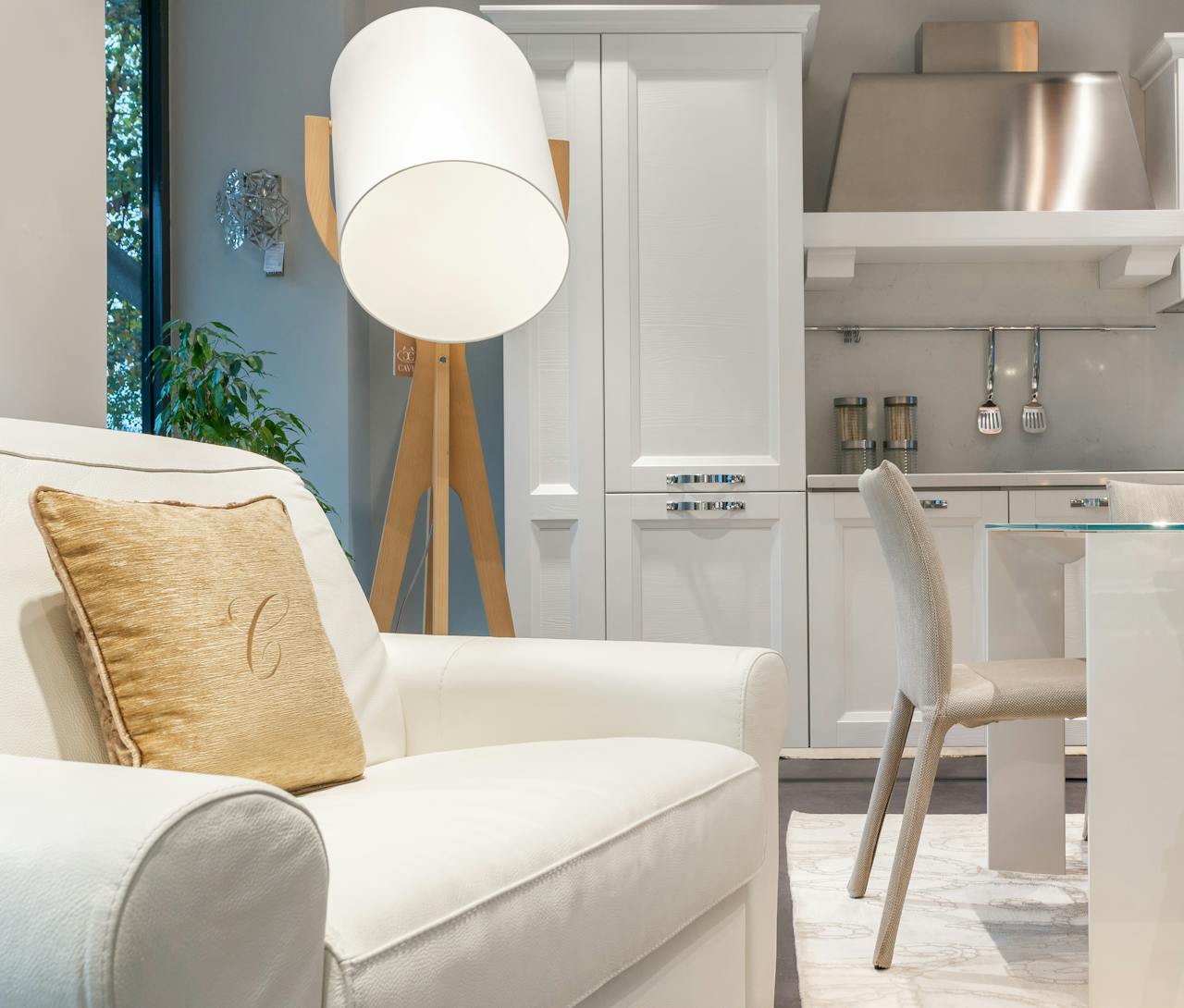 Stylish modern apartment interior featuring a cozy white armchair, elegant kitchen, and contemporary decor.
